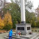 Dziecko zapala znicze pod pomnikiem na Skwerze Niepodległości