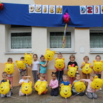 Dzieci trzyletnie pozują do zdjęcia z balonami.